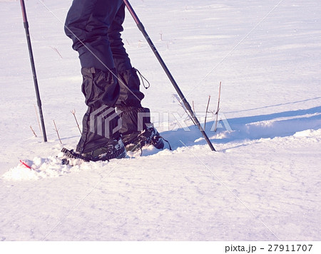 Man legs with snowshoes walk in snow. Detail  27911707