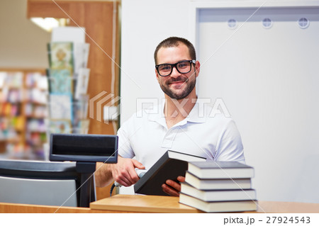 Salesman at the checkout in a bookstore 27924543