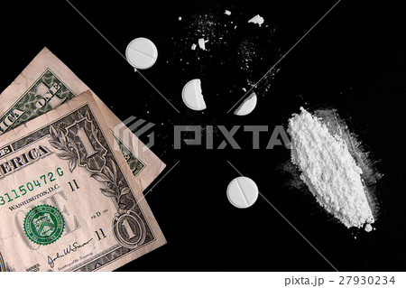 Drugs and money scattered on a black background Drugs and money scattered on a black background 27930234