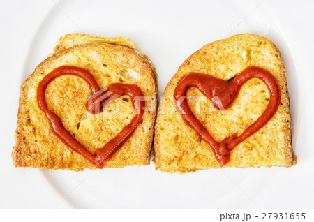 Two fried breads in the egg with hearts of ketchup 27931655