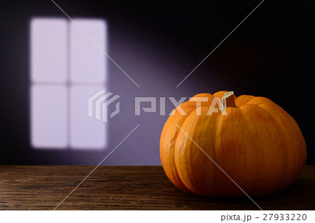 pumpkin on wooden table with window light 27933220