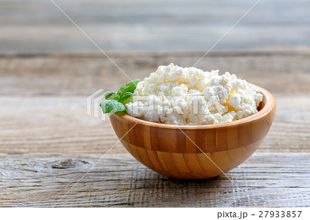 Homemade cottage cheese in a wooden bowl. 27933857