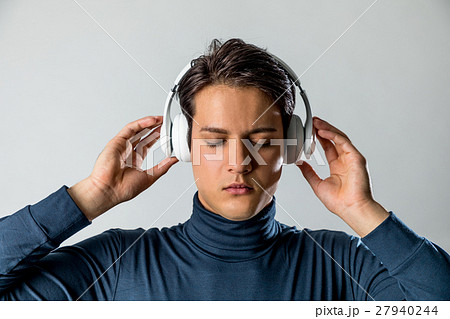 ワイヤレスヘッドホンで音楽を聴く男性の写真素材