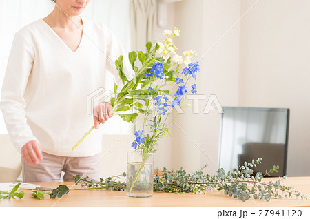 リビングで美しい花を活ける中年女性 27941120