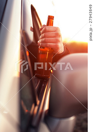 Drunk man drinking alcohol while driving a car 27943649