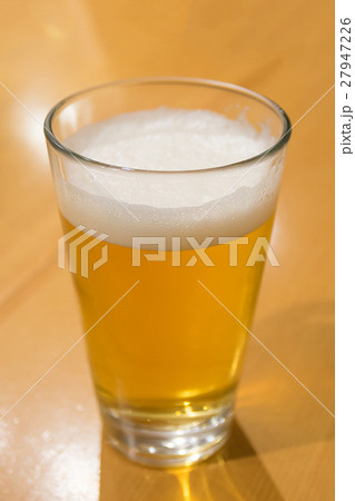 A glass of beer on the wood table 27947226