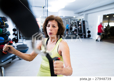 Senior woman in gym working out with weights. 27948739