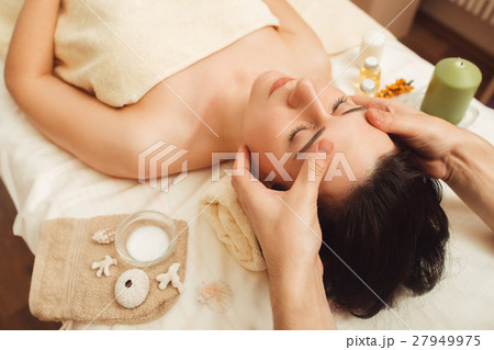 Woman having face massage at salon 27949975