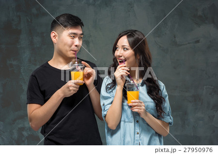 young pretty Asian couple with glasses of Orang young pretty Asian couple with glasses of Orang 27950976
