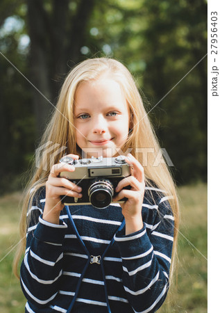 Cute little girl with a vintage camera. 27956403
