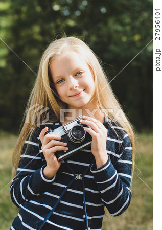 Cute little girl with a vintage camera. 27956404