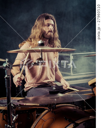 Young man with long hair playing drums Young man with long hair playing drums 27960510