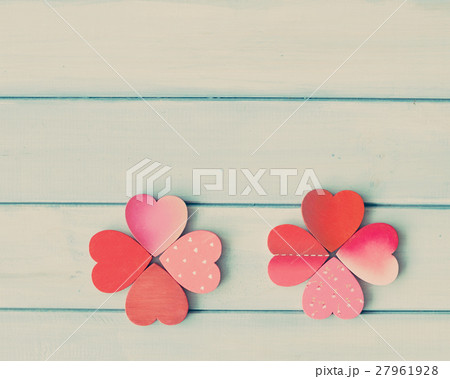Clovers formed by wood hearts over turquoise wood Clovers formed by wood hearts over turquoise wood 27961928
