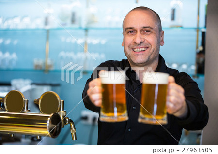 Portrait of bar tender offering beer Portrait of bar tender offering beer 27963605