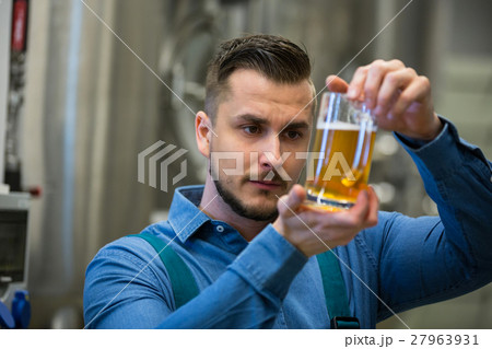 Close-up of brewer testing beer 27963931