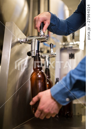 Brewer filling beer in bottle 27964014