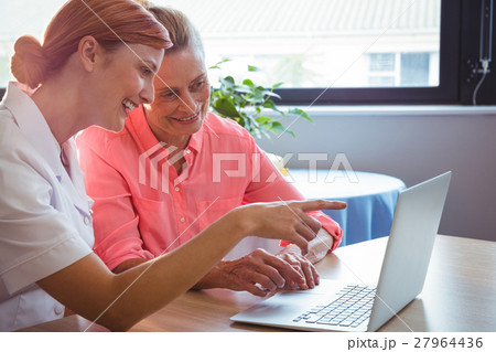 Nurse and senior woman using a laptop Nurse and senior woman using a laptop 27964436