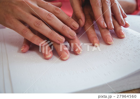 Nurse helping senior woman with braille Nurse helping senior woman with braille 27964560