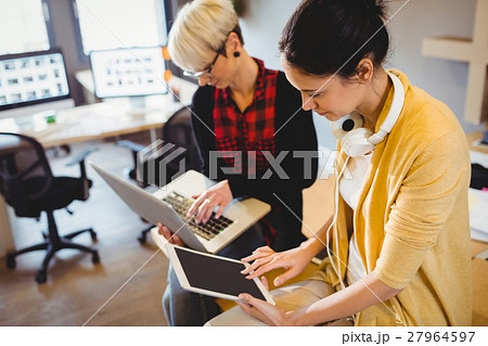 Two female graphic designer using digital tablet and laptop Two female graphic designer using digital tablet and laptop 27964597
