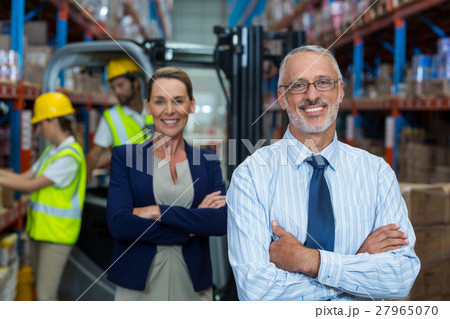 Focus of manages are smiling and posing with crossed arms 27965070