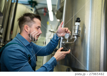 Brewer checking pressure at brewery Brewer checking pressure at brewery 27965482