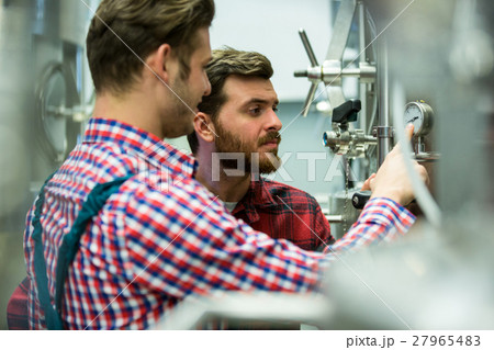 Maintenance workers examining pressure 27965483
