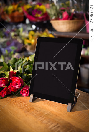 Bunch of roses and digital tablet on the wooden table Bunch of roses and digital tablet on the wooden table 27965523