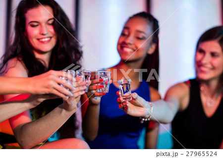 Group of friends toasting tequila shot glasses Group of friends toasting tequila shot glasses 27965524