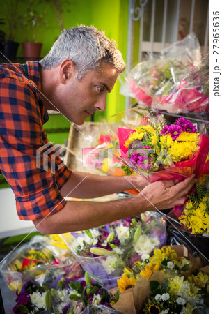 Male florist arranging flower bouquet Male florist arranging flower bouquet 27965636