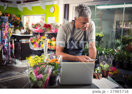 Male florist using mobile phone 27965716