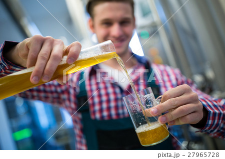 Brewer pouring beer in glass Brewer pouring beer in glass 27965728