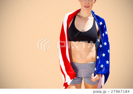 Composite image of sporty woman holding an american flag 27967184