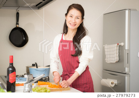 明るいキッチンに立つミドル女性 27979273