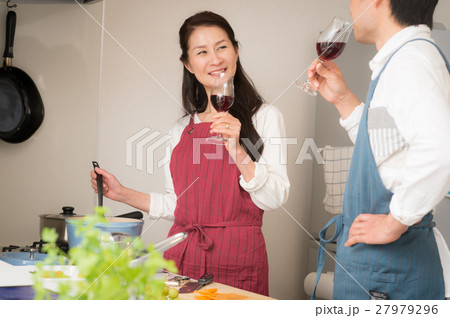 キッチンで乾杯するミドル夫婦 27979296