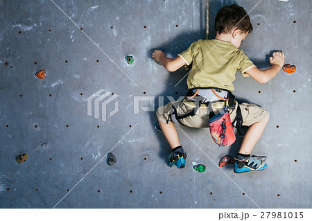 little boy climbing a rock wall indoor little boy climbing a rock wall indoor 27981015