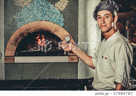 Busy chef at work in the restaurant kitchen Busy chef at work in the restaurant kitchen 27984787