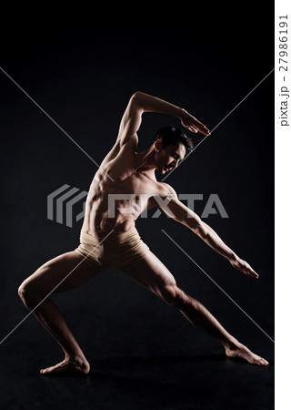 Handsome man practicing yoga in the dark lighted Handsome man practicing yoga in the dark lighted 27986191