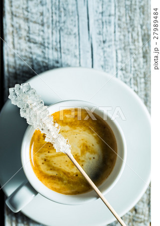 Crystallized sugar on wooden stick and coffee cup. Crystallized sugar on wooden stick and coffee cup. 27989484