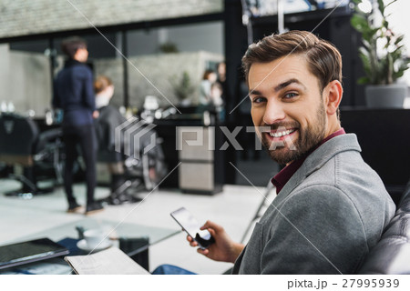 Cheerful man sitting in hairdressers 27995939