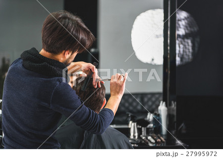 Professional stylist cutting male hair Professional stylist cutting male hair 27995972