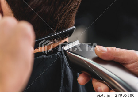 Skillful barber using shearer for haircut Skillful barber using shearer for haircut 27995980