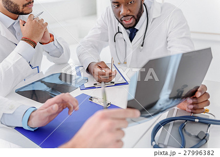 Skillful traumatologists discussing radiograph of 27996382