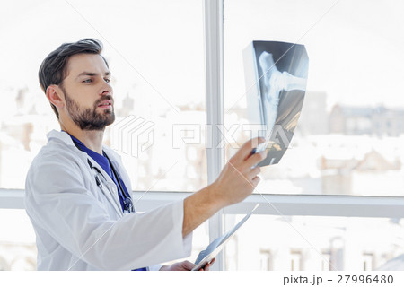 Smart male general practitioner looking at Smart male general practitioner looking at 27996480