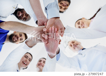 Happy general practitioners putting arms together Happy general practitioners putting arms together 27997247