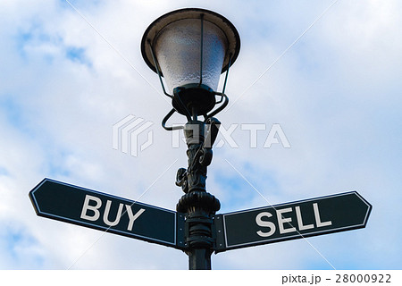 Buy versus Sell directional signs on guidepost Buy versus Sell directional signs on guidepost 28000922