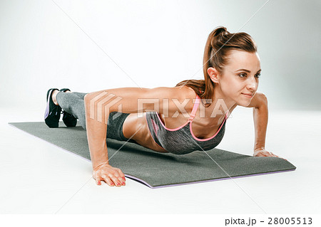 Beautiful slim brunette doing some push ups a the 28005513