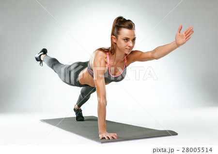 Beautiful slim brunette doing some push ups a the 28005514