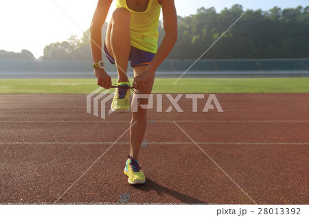 young fitness woman runner tying shoelace   28013392