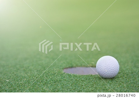 golf ball on lip of cup golf ball on lip of cup 28016740