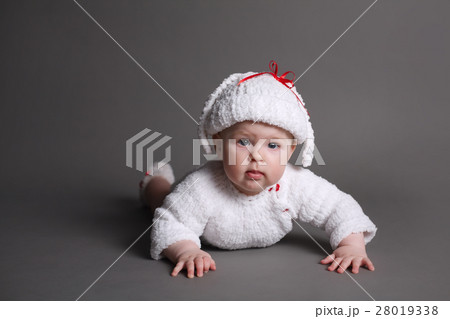 beautiful baby in a knit dress and cap 28019338